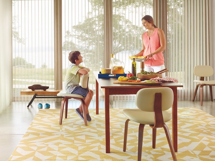 Woman and young child in dining room with food on table.